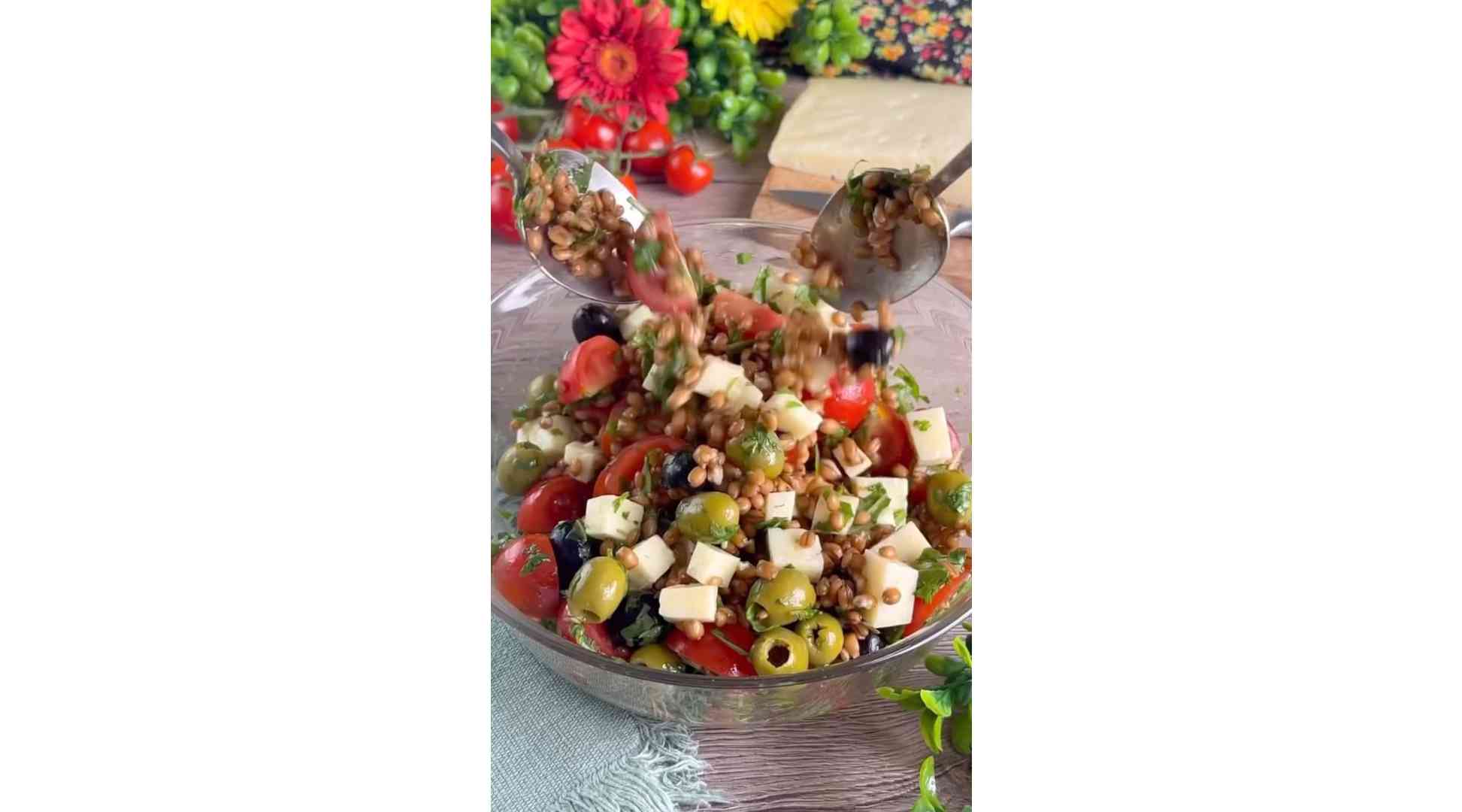 Mediterranean spelled salad is prepared with cherry tomatoes olives